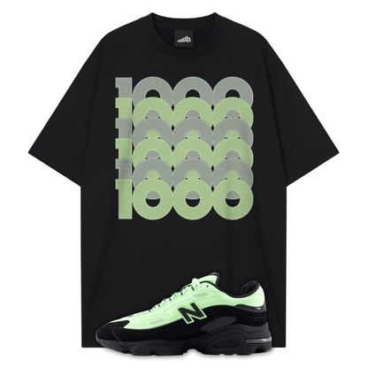 Black t-shirt pens with green and gray graphic design and a matching New Balance 1000 Black Neon Green sneakers on a white background