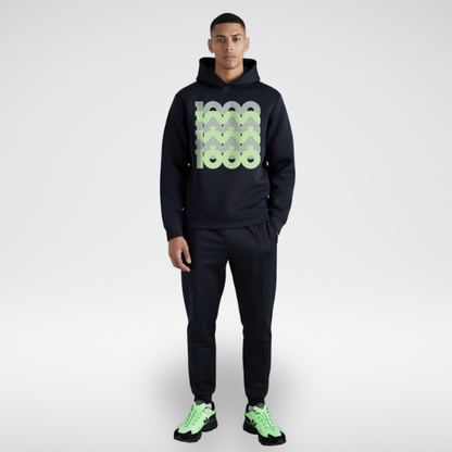 Man wearing a black hoodie van and New Balance 1000 Black Neon Green shoes, standing against a white background