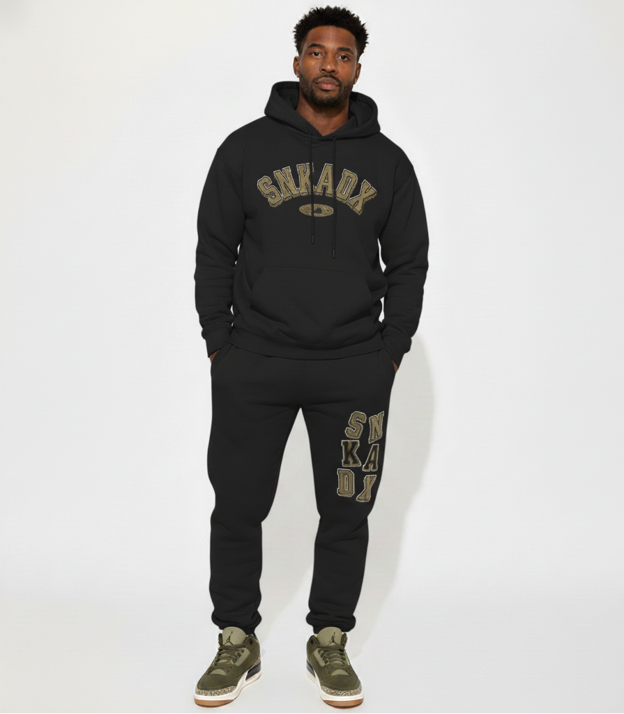 Person wearing a black hoodie and jogger set with 'SNKADX' branding on a white background
