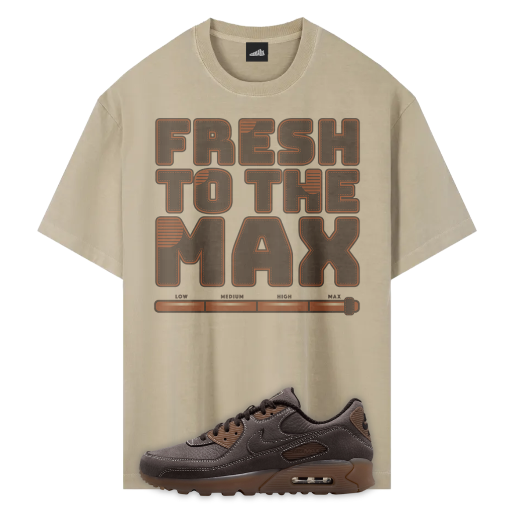 A beige graphic T-shirt with the words 'FRESH TO THE MAX' in large brown block letters and a horizontal progress-bar style graphic underneath, shown alongside a dark brown Nike Air Max Shadow Brown sneaker on a white background.