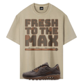 A beige graphic T-shirt with the words 'FRESH TO THE MAX' in large brown block letters and a horizontal progress-bar style graphic underneath, shown alongside a dark brown Nike Air Max Shadow Brown sneaker on a white background.
