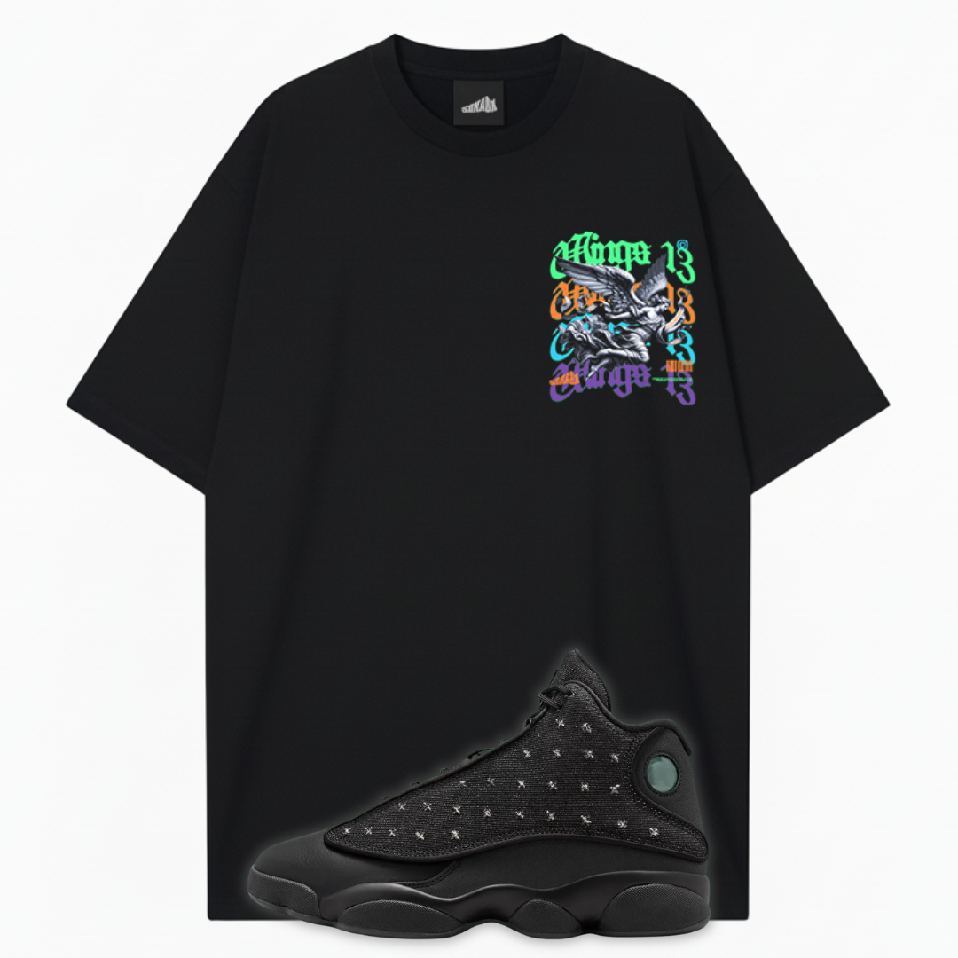 A black oversized short-sleeve t-shirt with a colorful graphic on the left chest and a black Air Jordan 13 Wings sneaker overlaid at the bottom, shown on a light gray background.