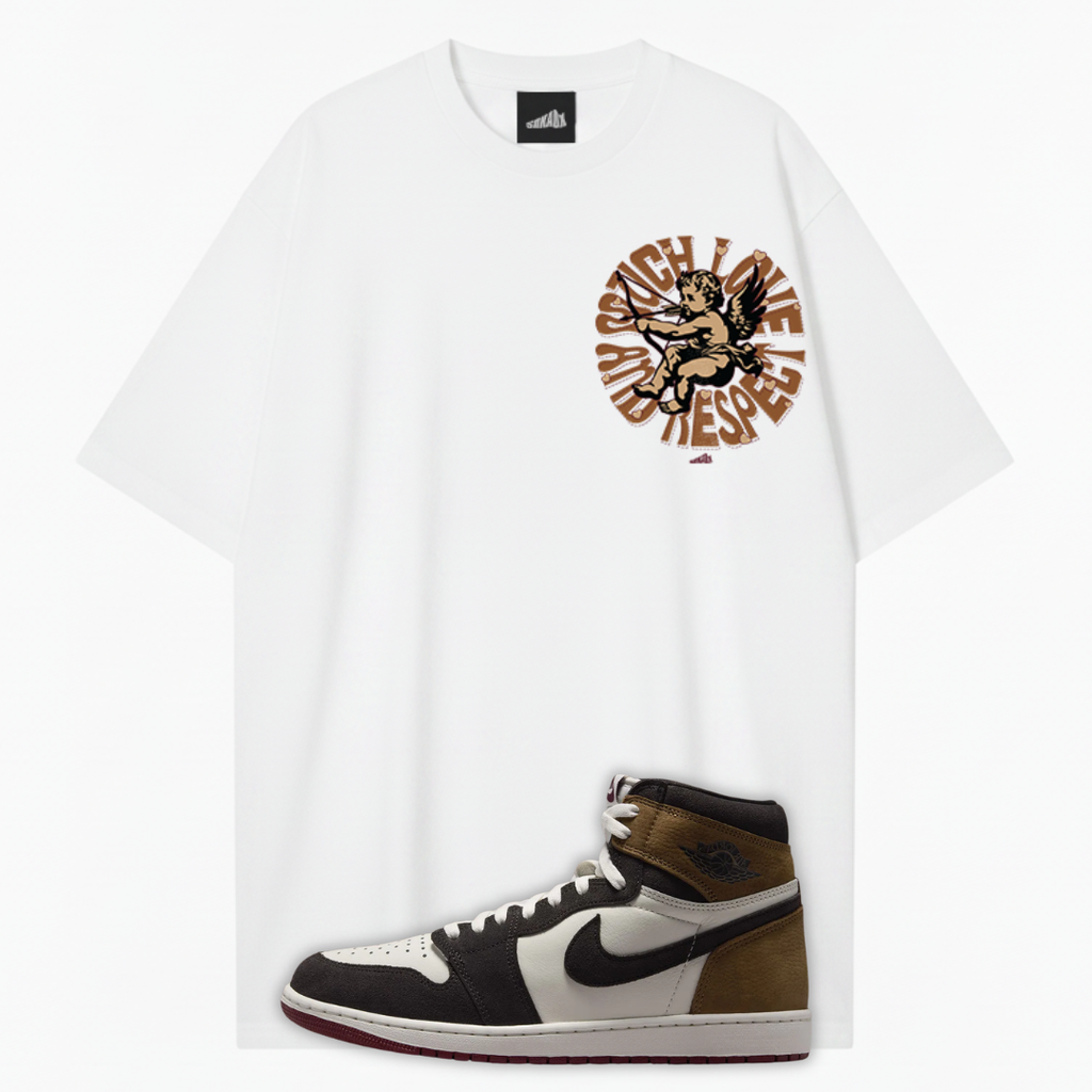 A white oversized T-shirt with a brown and black graphic print on the left chest, shown flat against a light gray background with a brown, black, and white Jordan 1 Love Letter high-top sneaker placed at the bottom.