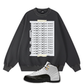 Black sweatshirt with graphic design and a pair of Air Jordan 12 Taxi sneakers on a white background
