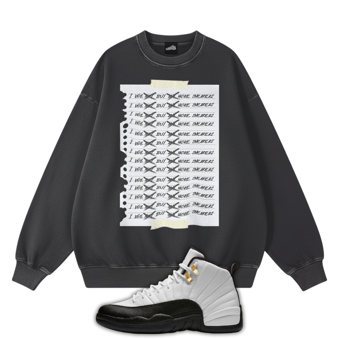 Black sweatshirt with graphic design and a pair of Air Jordan 12 Taxi sneakers on a white background