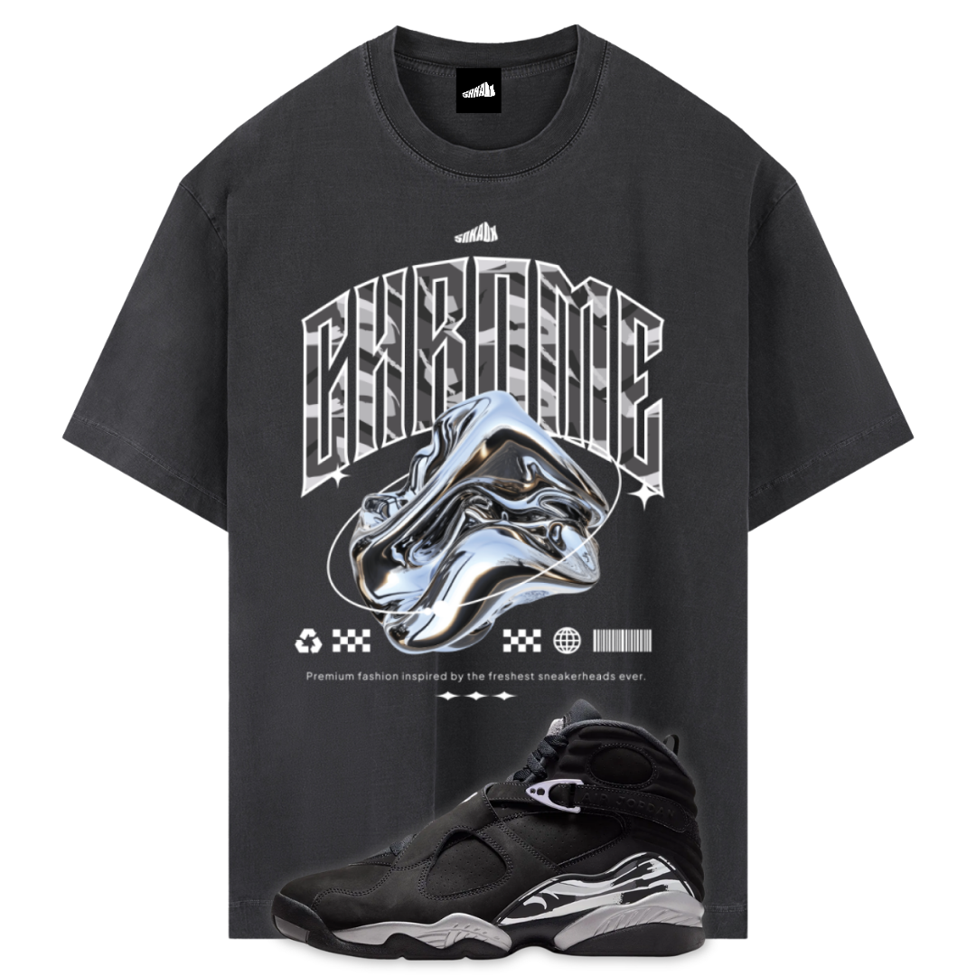 A black graphic t-shirt featuring a large chrome sneaker design and the word 'CHROME' in a metallic font, shown alongside a Air Jordan 8 Chrome sneaker on a white background.