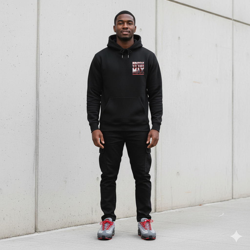 Man wearing a black hoodie with Fresh To The Max logo against a light gray wall
