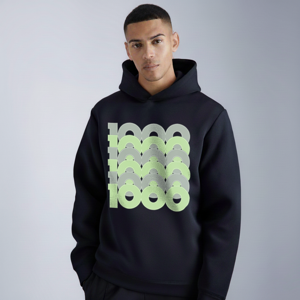 Man wearing a black hoodie with a green and gray pattern on a plain background