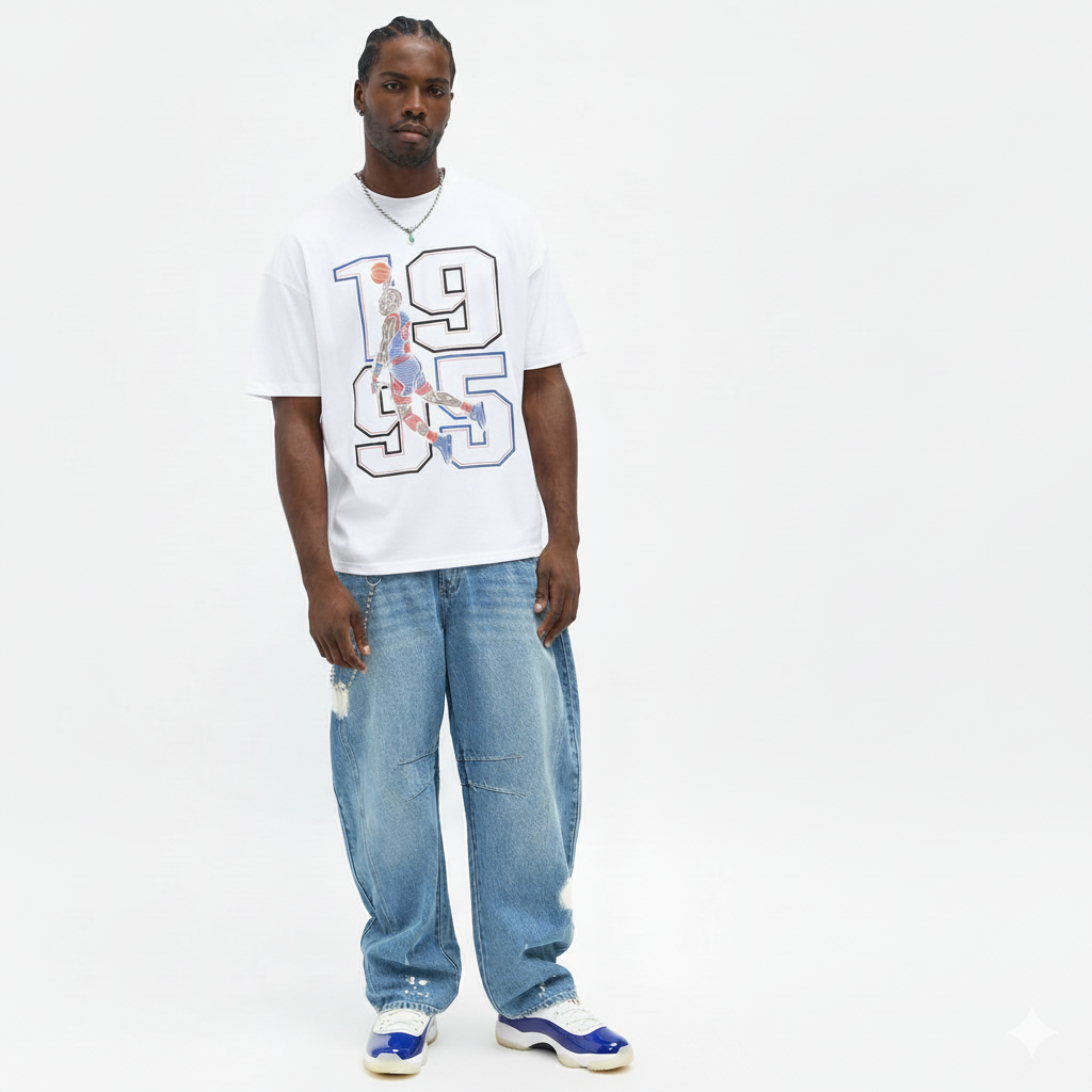 Man wearing a white t-shirt with a Jordan dunking graphic design and blue jeans on a white background