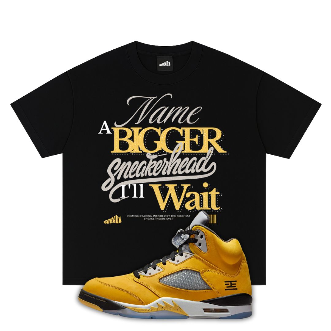 Black t-shirt with yellow and white text and a Air Jordan 5 Tokyo 2025 sneaker on a white background