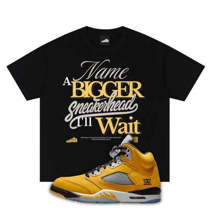 Black t-shirt with yellow and white text and a Air Jordan 5 Tokyo 2025 sneaker on a white background