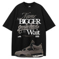 Black t-shirt with white text and a gray Air Jordan 4 Cave Stone on a white background