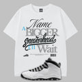 White t-shirt with graphic text and a white sneaker on a gray background