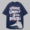 Navy blue t-shirt with humorous text design and a Air Jordan 12 French Blue sneaker on a gray background