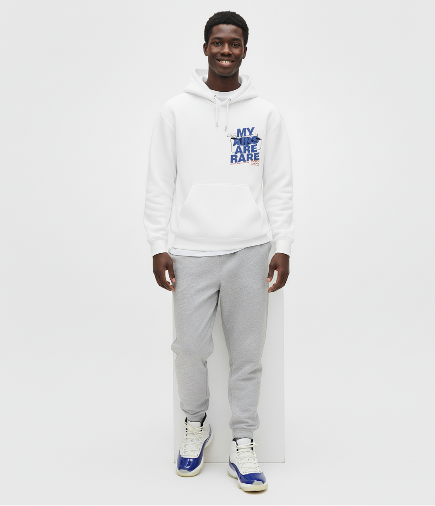 Person wearing a white hoodie with text Air Jordan 11 Rare Air sneakers and gray pants on a white background