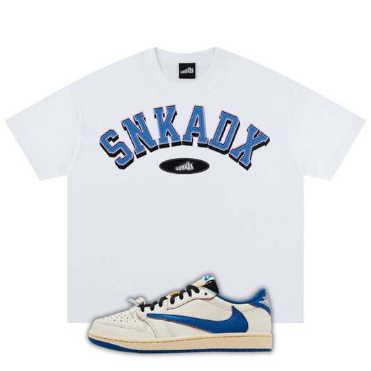 White t-shirt with blue text and a white fragment x Travis Scott x Air Jordan 1 Low White/Blue sneaker with blue accents on a white background