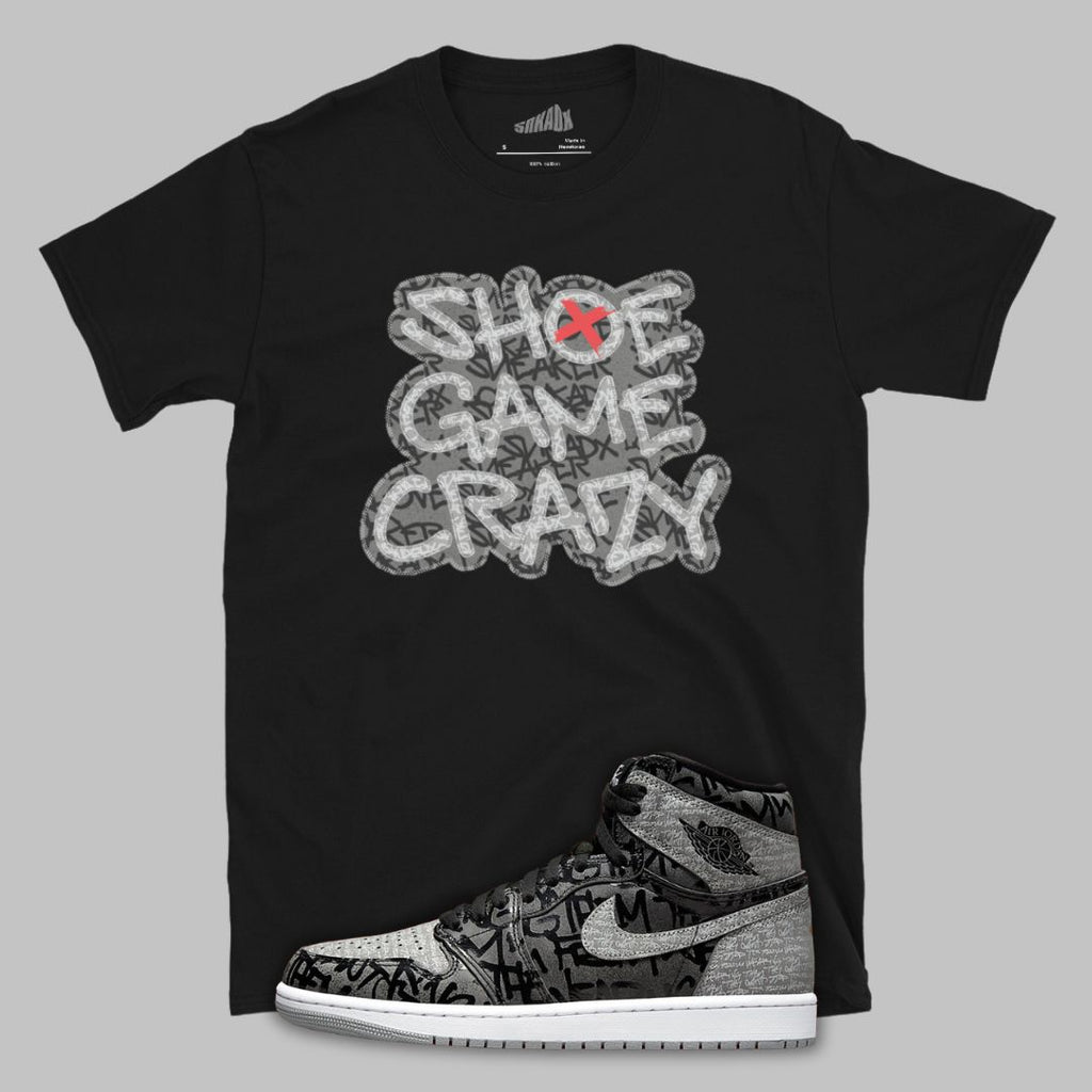 Black t-shirt with 'Shoe Game Crazy' graphic and a sneaker design on a gray background