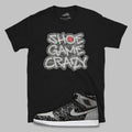Black t-shirt with 'Shoe Game Crazy' graphic and a sneaker design on a gray background