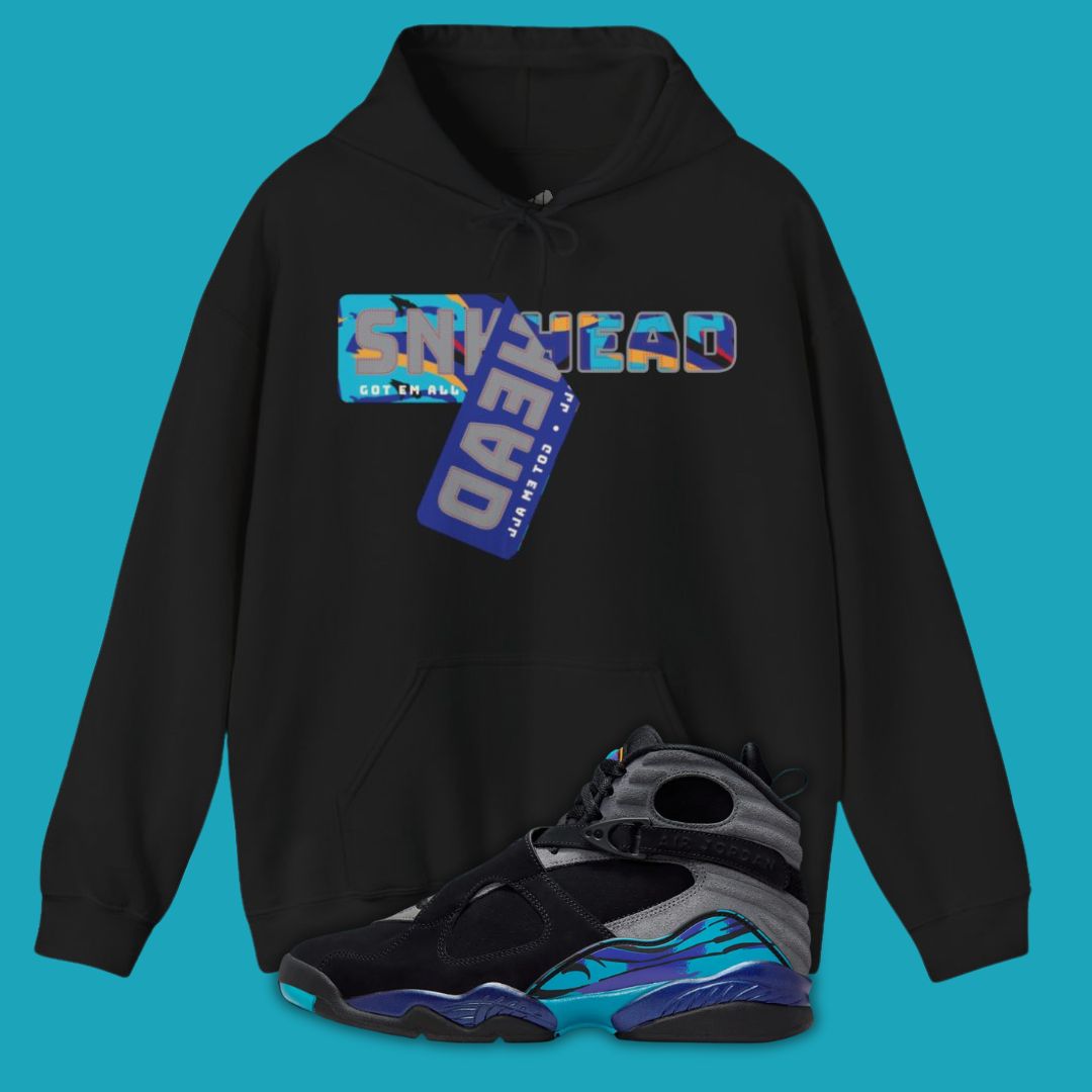 Black hoodie with colorful text design on a blue background, paired with black and blue sneakers.