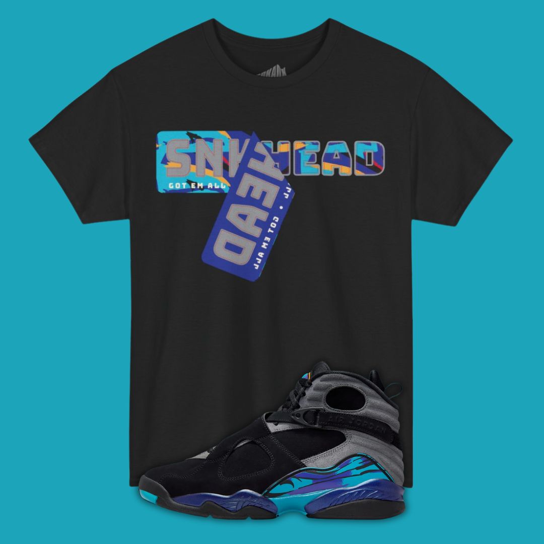 Black t-shirt with colorful graphic design on a blue background, featuring a sneaker below.