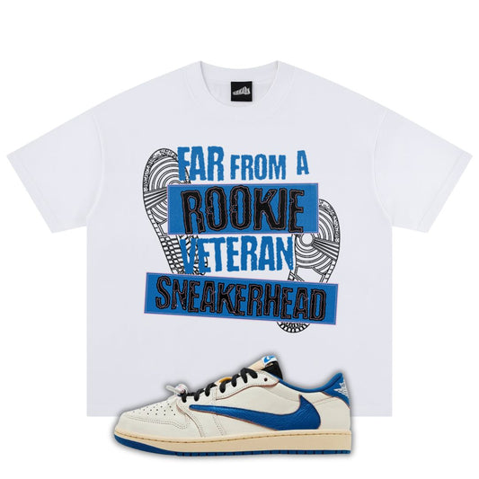 White t-shirt with sneakerhead graphic and text, paired with a fragment x Travis Scott x Air Jordan 1 Low White/Blue sneaker on a white background