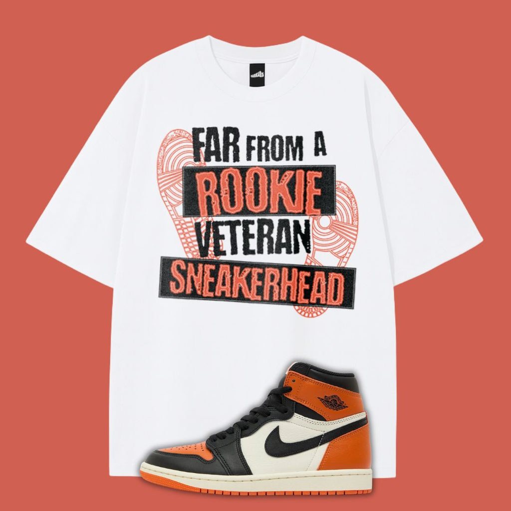 White t-shirt with 'Far From a Rookie Veteran Sneakerhead' text and an Air Jordan 1 Shattered Backboard sneaker on a red background