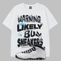 White t-shirt with Warning Highly Likely to Buy Sneakers graphic text and a sneaker on a gray background