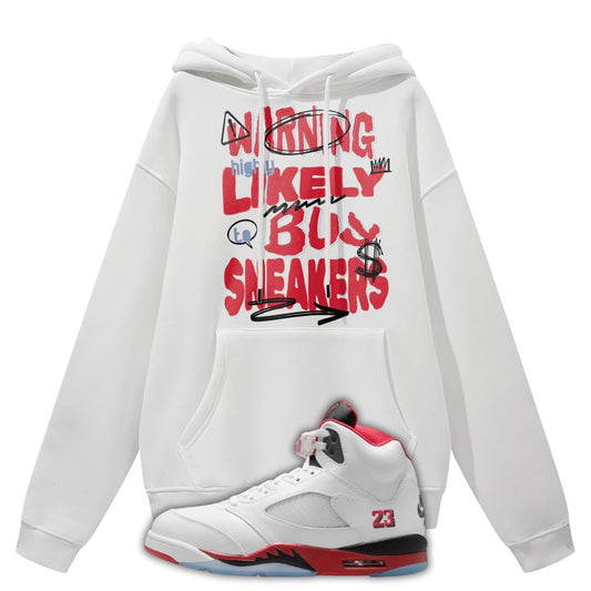 White hoodie with colorful text that says Warning Highly Likely To Buy Sneakers and a white Air Jordan 5 Fire Red sneaker on a white background 