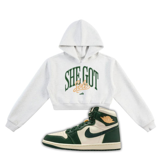 White hoodie with 'SHE GOT SOLE' text and a green and white Air Jordan 1 on a white background