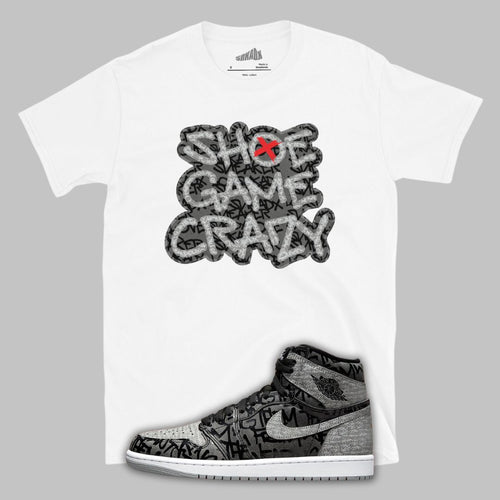 White t-shirt with 'Shoe Game Crazy' graphic and Jordan 1 Rebellionaie shoe design on a gray background