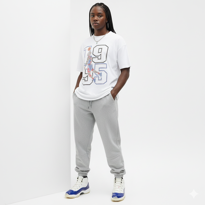 Woman wearing a white t-shirt with a graphic design and gray sweatpants against a white background