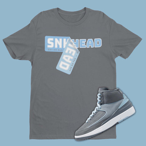 Grey t-shirt featuring a graphic of peeling Sneakerhead Sticker, designed to complement the sleek and stylish Air Jordan 2 Cool Grey sneakers
