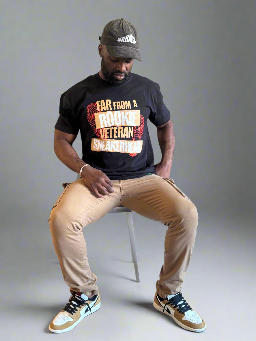 man sitting wearing black tee to match air jordan 1 rookie of the year low